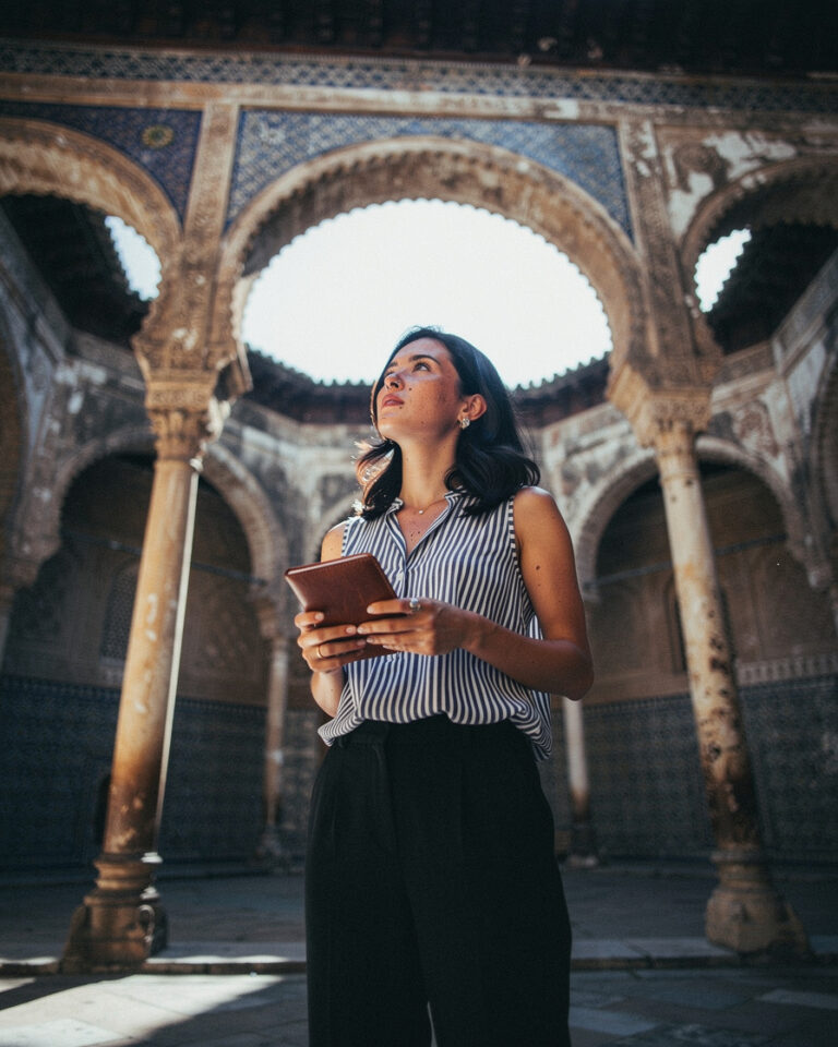 Tiled arches and central fountain in the Real Alcázar courtyard in Seville, soft indirect morning light, nearly empty space.