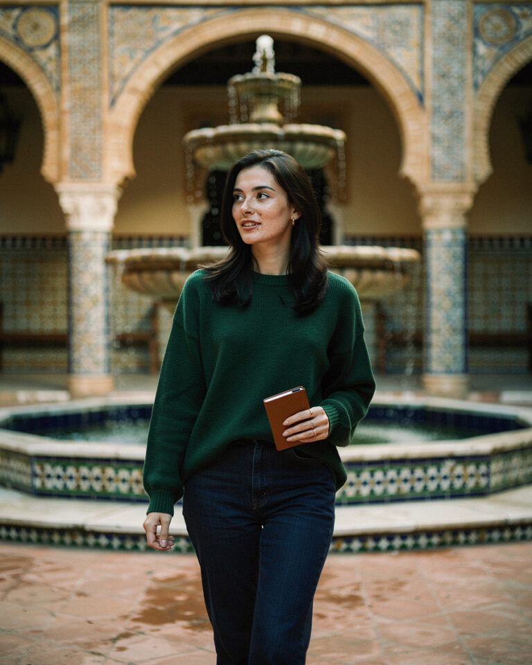 Tiled arches and central stone fountain in the Real Alcázar courtyard in Seville, soft indirect morning light, nearly empty space.