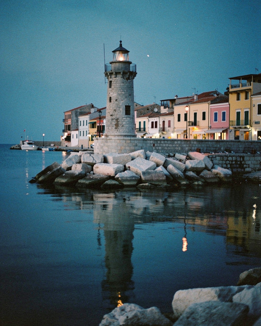 chania harbor dusk photography: Venetian lighthouse and pastel buildings along Chania harbor reflected in perfectly still wat