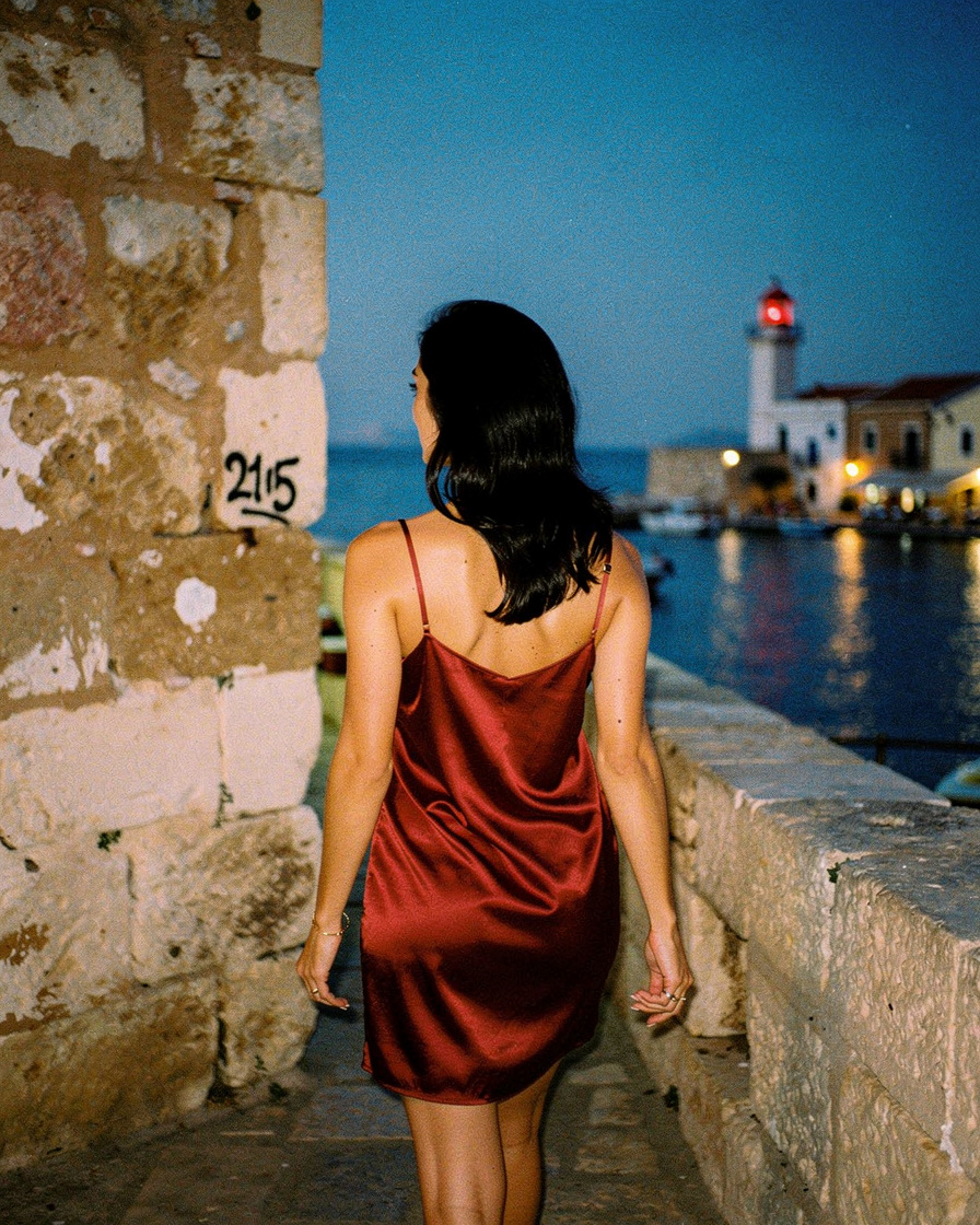 rethymno harbor dusk crete: Venetian harbor of Rethymno at dusk, small raki glass on a low table near the harbor wall, lighth